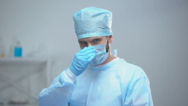 Cirujano profesional quitándose la mascarilla médica después de una operación exitosa — Vídeo de stock
