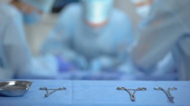 Ameliyat yapan profesyonel cerrah ekibi, masada sterilize edilmiş alet
