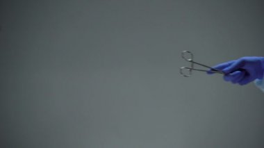Karanlık arka plana karşı makas veren cerrah, yasadışı karaborsa cerrahisi