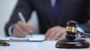 Gavel yargı sembolü olarak blok üzerinde, avukat arka plan üzerinde kanıt imza
