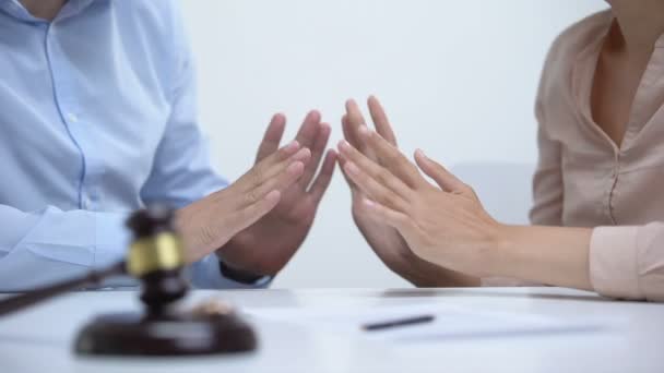 Cônjuges discutindo sobre a divisão de propriedade durante o divórcio, martelo e anéis close-up — Vídeo de Stock