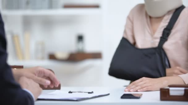 Insurance agent shaking hand with woman in arm sling, psychological support — Stock Video