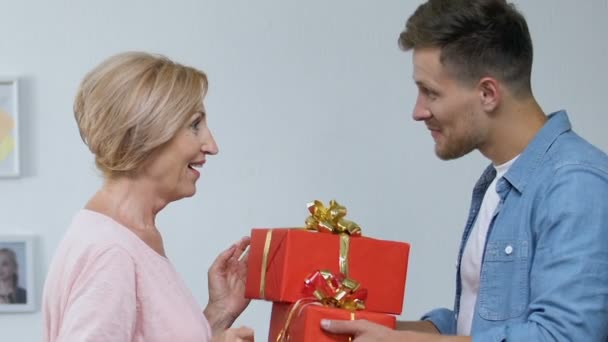 Zoon presenteert geschenk aan moeder, ontevreden vrouw kijken naar camera, aandacht gebrek — Stockvideo