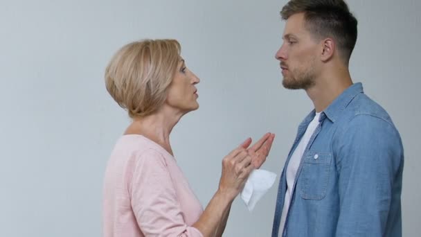Зрелая мать вытирает сыновьям рот, шокированная жена чувствует себя растерянной, сверхзащитой — стоковое видео