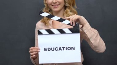Genç kadın tahta arka plan üzerinde alkış tutan, eğitim, gelecek başlatmak