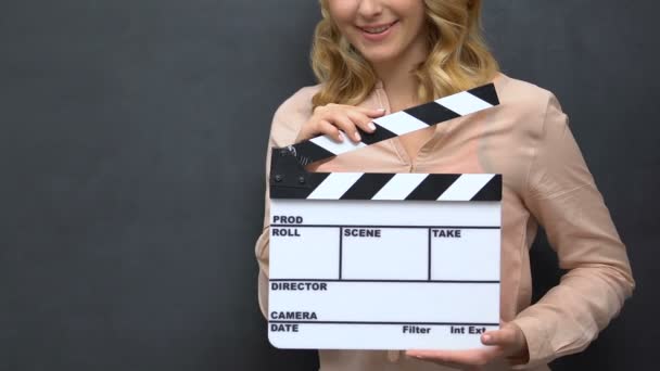 Young lady clapping with flapper isolated on blackboard background film shooting — Stock Video