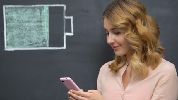 女人在手机上上网，电池符号绘制，能源效率 — 图库视频影像