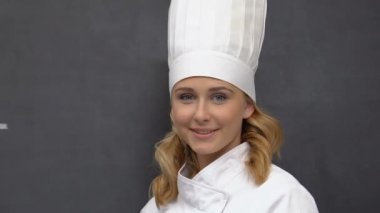 Vegan tahtaya yazılmış, kadın aşçı kameraya gülümseyen, özel diyet gıda