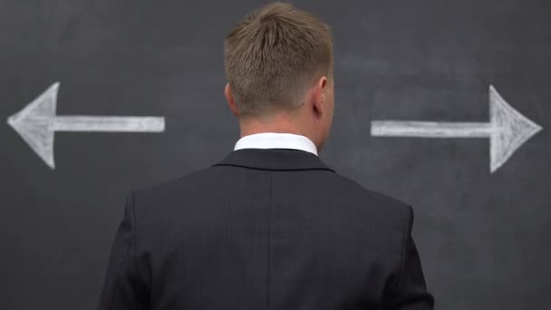男西装男选择发展方向，黑板上的箭头 — 图库视频影像