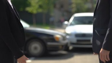 İş elbisesi giyen erkek ve kadın toplantıdan sonra el sıkışırken, başarılı bir anlaşma