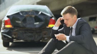 Sinirli erkek sürücü telefon konuşurken, araba kazasındasonra yatıştırıcı hapları alarak, hasar