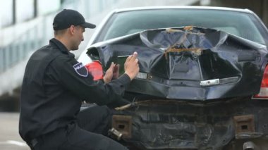 Trafik kazası sonrası kaza yapan otomobilin fotoğraflarını yapan polis memuru, raporu doldurdu