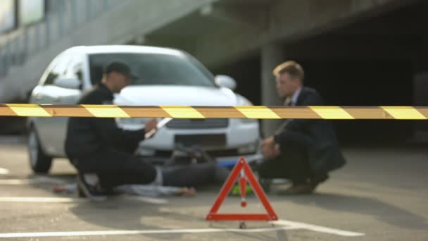 Policía con conductor escribiendo informe tras accidente con bicicleta, escena del crimen — Vídeo de stock