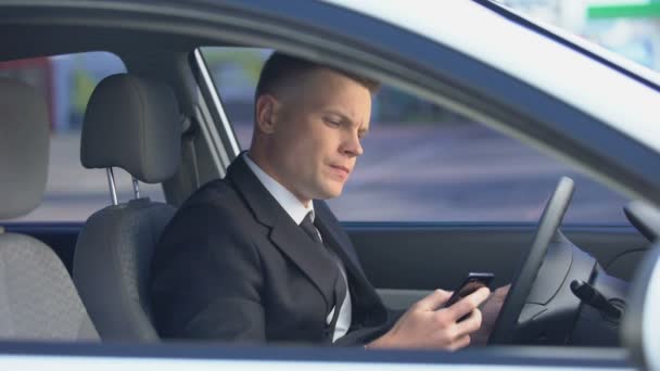 Nervös man i kostym sitter på förarsätet och ringer på telefon, sent till jobbet — Stockvideo