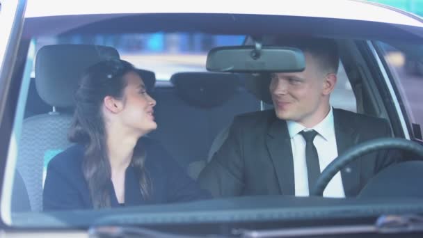 Pareja alegre sonriendo y besándose modestamente en el coche después de la primera cita, romance — Vídeos de Stock