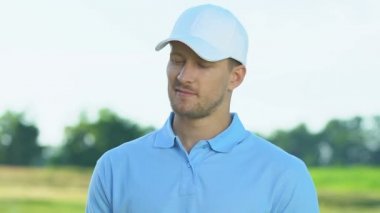 Gülümseyen golf oyuncusu kamera, hobi, eğlence aktivitesi poz demir kulüp tutan