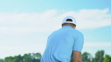 Adam golfçü topa vurduktan sonra bitirme pozisyonunda duran, mesafe izlerken