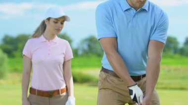 Kadın golf acemi oyuncu profesyonel topa vurmak adam hayran, yarı salıncak