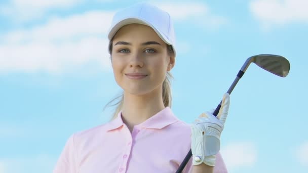 Atrakcyjna kobieta w mundurze Golfer i z klubem stwarzające do kamery, luksusowe hobby — Wideo stockowe