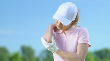 Golf turnuvası sonrası dirsek masajı genç kadın, profesyonel yaralanma