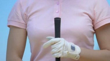 Özenli kadın golf kulübü ile temel pozisyon alarak, topa vurmaya hazır, putt