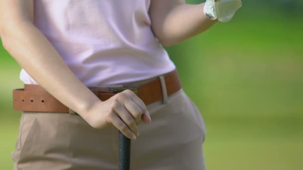 Female golf player holding ball and club waiting for opponent on golf course — Stock Video