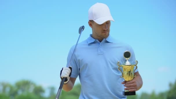 Stilig golfare poserar med Club och Golden Cup i händerna, vinnare, Triumph — Stockvideo