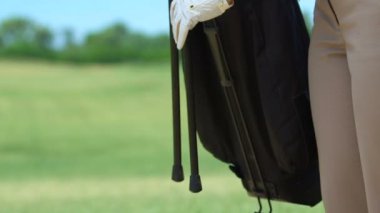 Woman fairway golf standı çanta koyarak, kulüp alarak ve vurmak için hazırlanıyor
