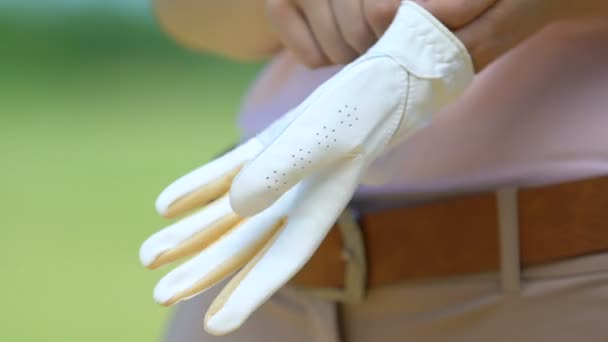 Primer plano jugador de golf femenino profesional que usa y ajusta el guante de cuero — Vídeos de Stock