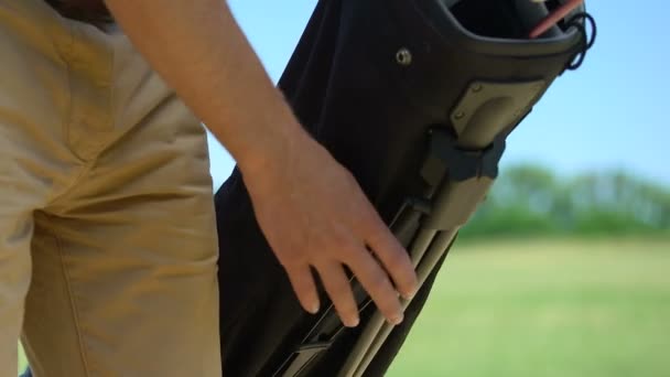 Erkek golfçü golf standı çanta yerleştirerek, uygun kulüp seçimi ve vurmak için hazırlanıyor — Stok video