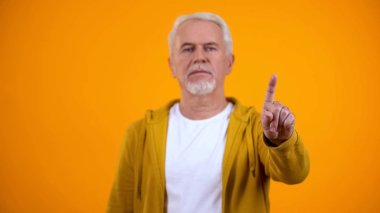 Elderly male in casual clothes showing warning finger gesture, rejection sign clipart