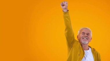 Neşeli yaşlı erkek el germe, kamera, başarı ve şans gülümseyerek