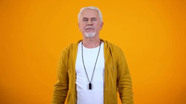 Deneyimli yaşlı spor antrenörü turuncu arka plan, meslek kamera bakıyor