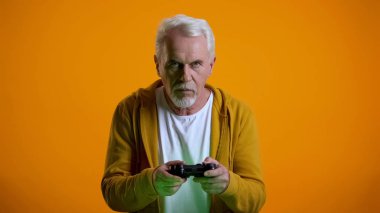 Joystick videooyunu oynarken ciddi üst düzey adam, gadget bağımlılığı sorunu