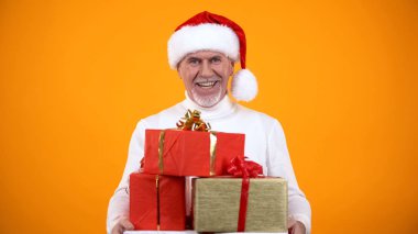 Gizli kıdemli santa hediye kutuları sunan ve kamera, tatil satış gülümseyerek