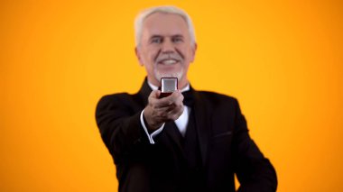 Gülümseyen kıdemli erkek kamera, takı reklam, romantik hediye teklif yapma