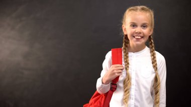 Sırt çantası ile mutlu kız tahta arka plan, eğitim üzerinde kamera gülümseyen