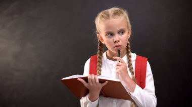 Kalem ve copybook karmaşık görev hakkında düşünme ile Düşünceli kız öğrenci