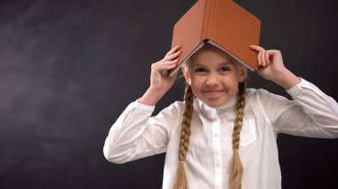 Kamera, eğitim kavramı gülümseyen baş kitap ile heyecanlı kız öğrenci