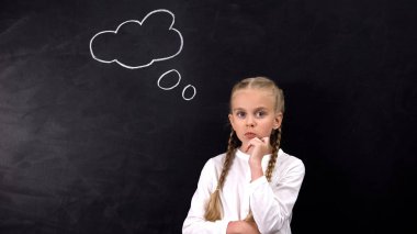 Zor görevi düşünen kız öğrenci, tahtaya boyanmış fikir işareti