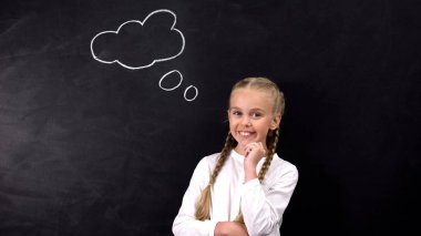 Kameraya bakan gülümseyen öğrenci, tahtada fikir işareti, yaratıcılık kavramı