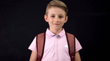 Okul çocuğu tahta arka plan karşı kamera bakıyor, okula geri