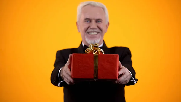 Cheerful Male Retiree Suit Presenting Red Giftbox Camera Birthday Present — Stock Photo, Image