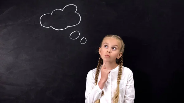 Thoughtful Schoolgirl Touching Chin Looking Side Idea Sign Blackboard — Stock Photo, Image