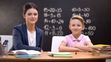 Mutlu öğretmen ve akıllı öğrenci kameraya gülümseyen, modern eğitim reformu