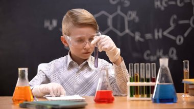 Test tüpünde kimyasal maddeye bakan öğrenci, kimya dersi, hobi