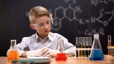 Okul deneycisi sıvıile test tüpleri bakarak, reaksiyonları analiz