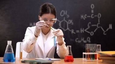 Kimya öğrencisi laboratuvarda test tüpü yapma deneyi sıvı damlama