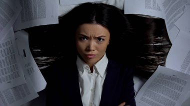 Kızgın iş kadını belgeler arasında yatan, sevilmeyen işten nefret eden, motivasyoneksikliği