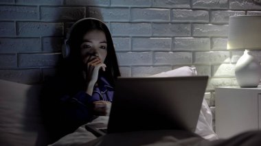 Kulaklıklı kadın drama filmi izlerken, karakterler için endişe, boş zaman